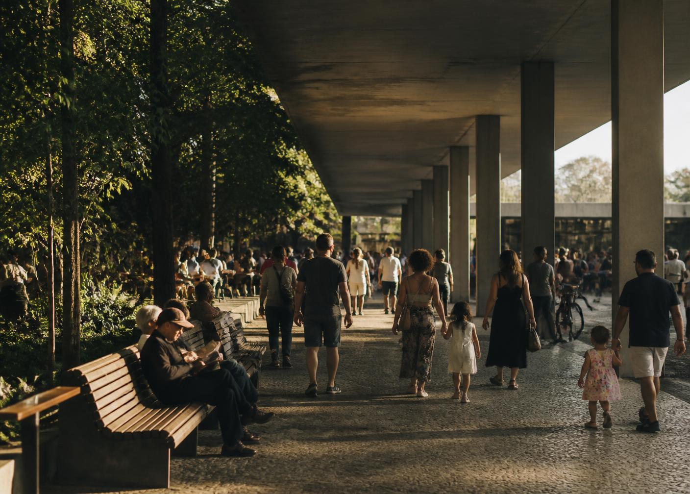 Pessoas caminhando e convivendo em um espaço público urbano ao fim da tarde